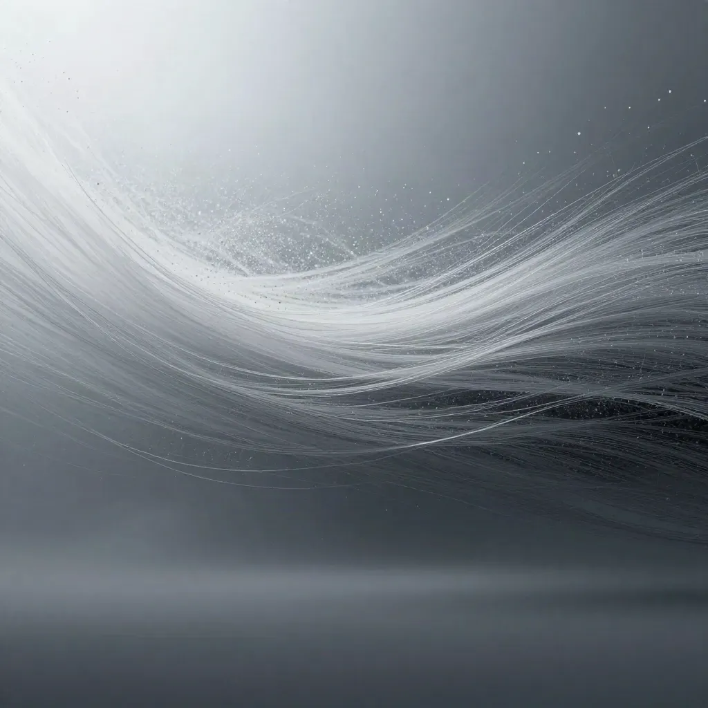 Silver filaments bloom in a deep graphite haze, with soft white light and drifting motes.